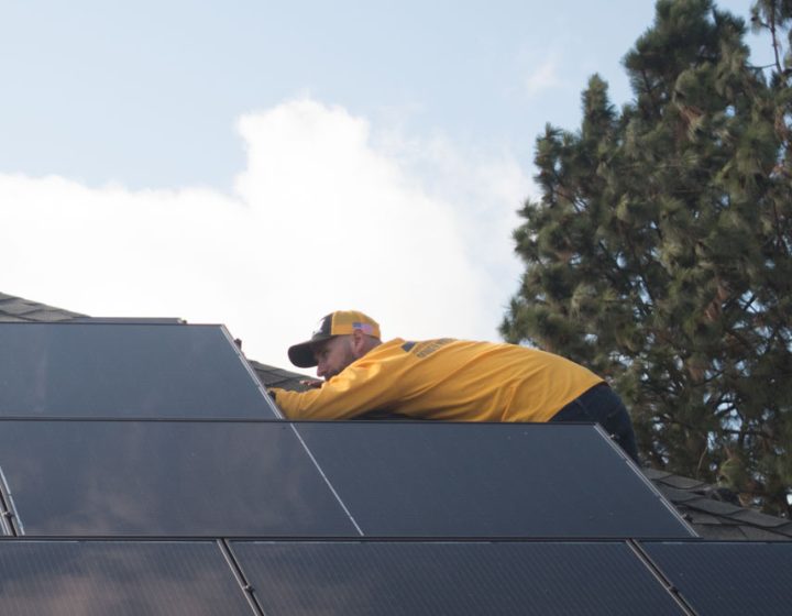 a technician fixing solar panels on the roof